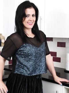 Темноволосая домохозяйка с большой задницей оголяет шикарные дойки на кухне - фото
