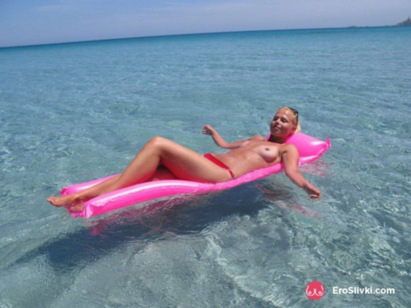 Русская блондиночка на море загорает топлесс - фото